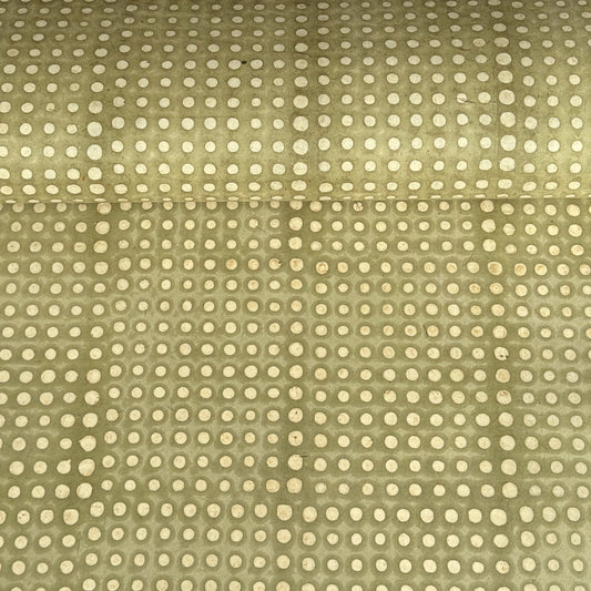 a sheet of Nepalese batik lokta paper in sage green with a repeat white dot design.