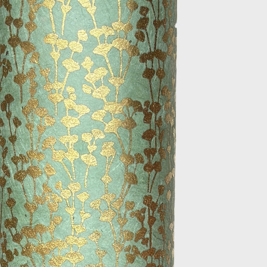 nepalese hand printed lokta paper with a small gold abstract gingko design on green lokta paper. Close up