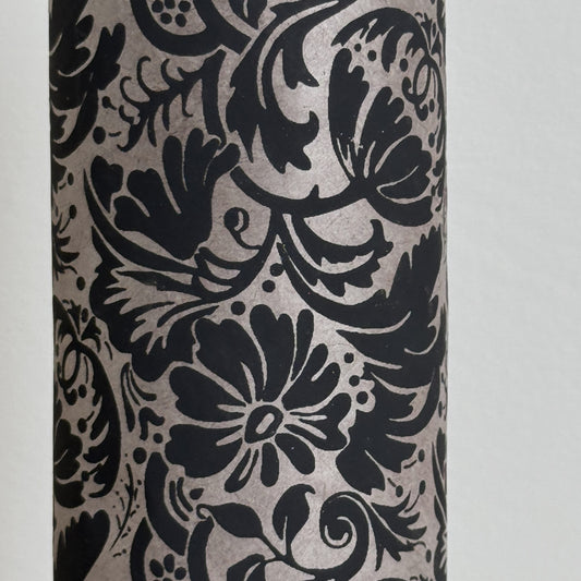 Nepalese handmade decorative lokta paper sheet with a black floral pattern screen printed on a dark taupe lokta paper. Close up