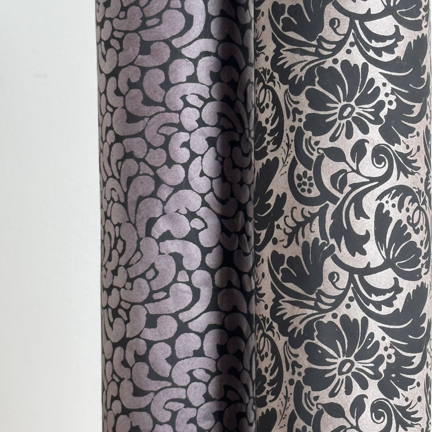 Nepalese handmade decorative lokta paper sheet with a black floral pattern screen printed on a dark taupe lokta paper. Rolled