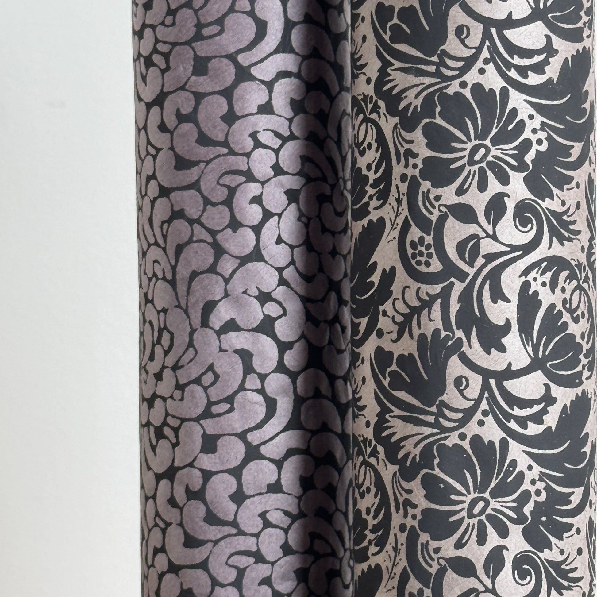 Nepalese handmade decorative lokta paper sheet with a black floral pattern screen printed on a dark taupe lokta paper. Rolled