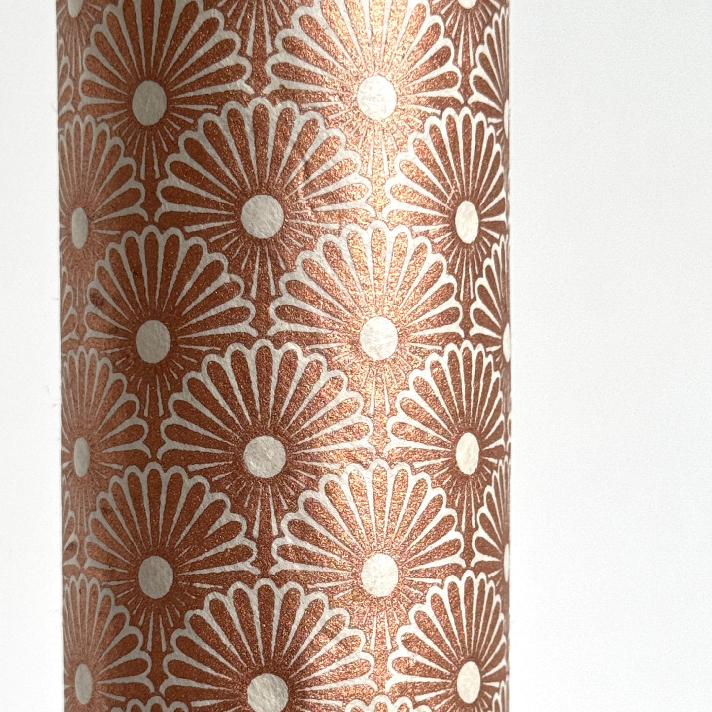 Nepalese handmade decorative lokta paper sheet with a copper metallic repeat floral pattern screen printed on an ivory lokta paper. close up