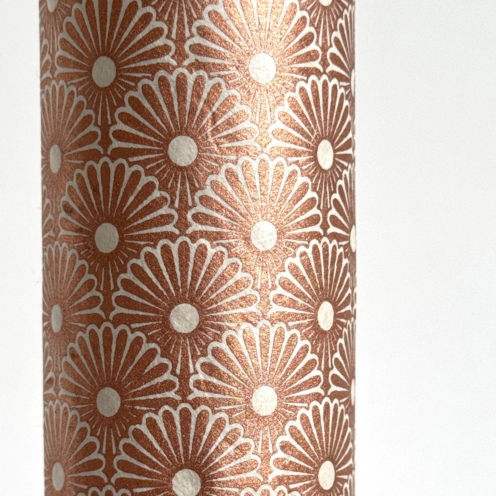 Nepalese handmade decorative lokta paper sheet with a copper metallic repeat floral pattern screen printed on an ivory lokta paper. close up