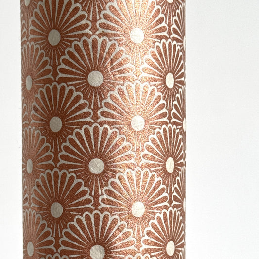 Nepalese handmade decorative lokta paper sheet with a copper metallic repeat floral pattern screen printed on an ivory lokta paper. close up