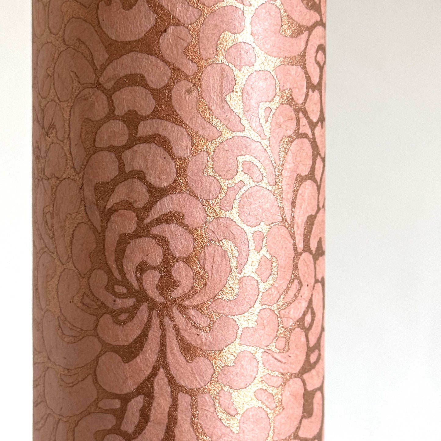 Nepalese handmade decorative lokta paper sheet with a metallic copper floral print screen printed on a blush pink lokta paper. close-up
