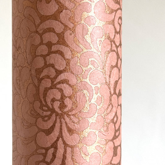 Nepalese handmade decorative lokta paper sheet with a metallic copper floral print screen printed on a blush pink lokta paper. close-up