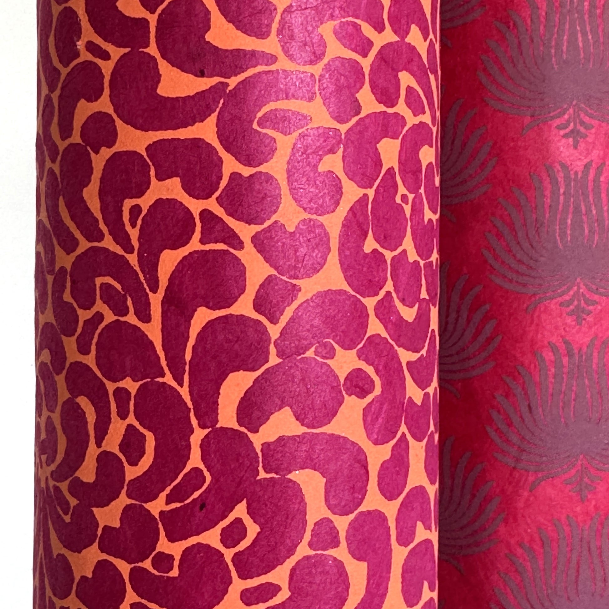 Nepalese handmade lokta paper sheet with a screen printed coral floral design on fuchsia lokta paper. close up