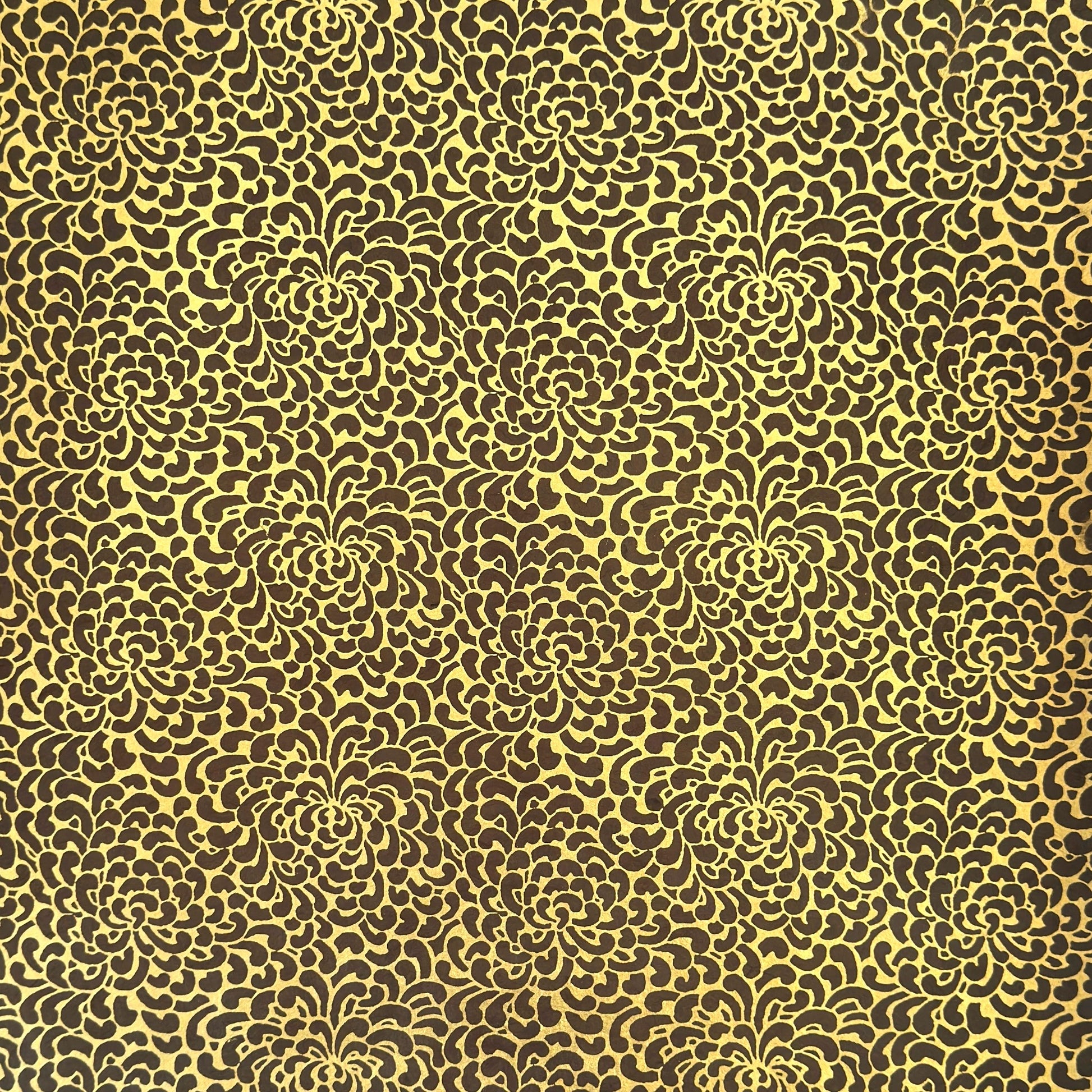 Nepalese handmade decorative lokta paper sheet with a gold screen printed floral design on a brown dyed lokta paper.