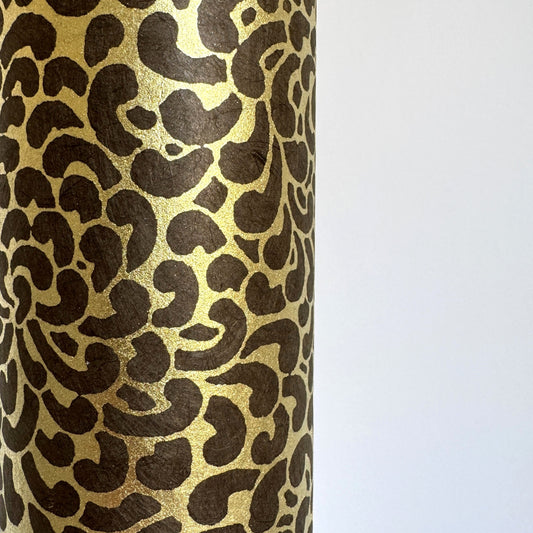 Nepalese handmade decorative lokta paper sheet with a gold screen printed floral design on a brown dyed lokta paper. Close-up