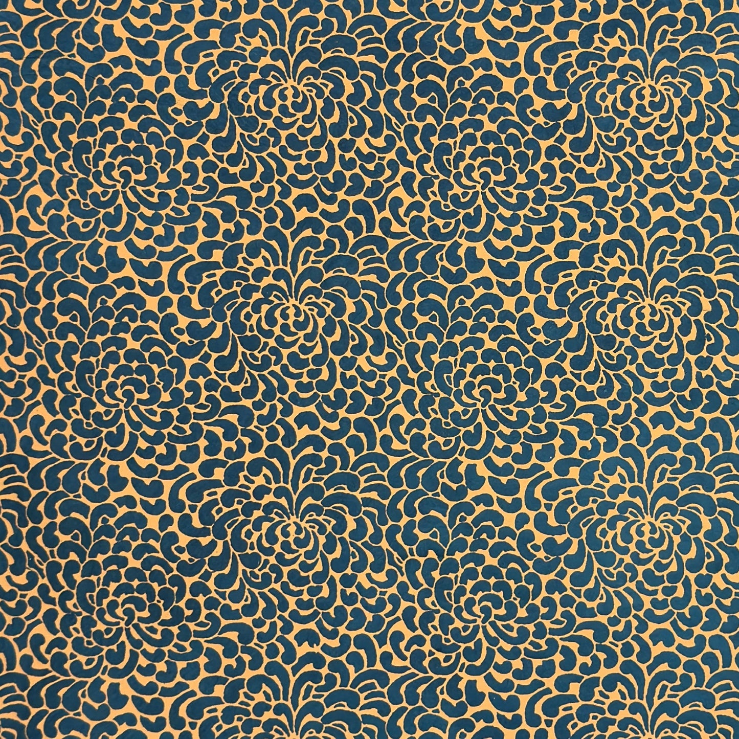 Nepalese handmade decorative lokta paper sheet with a saffron floral print screen printed on a teal lokta paper