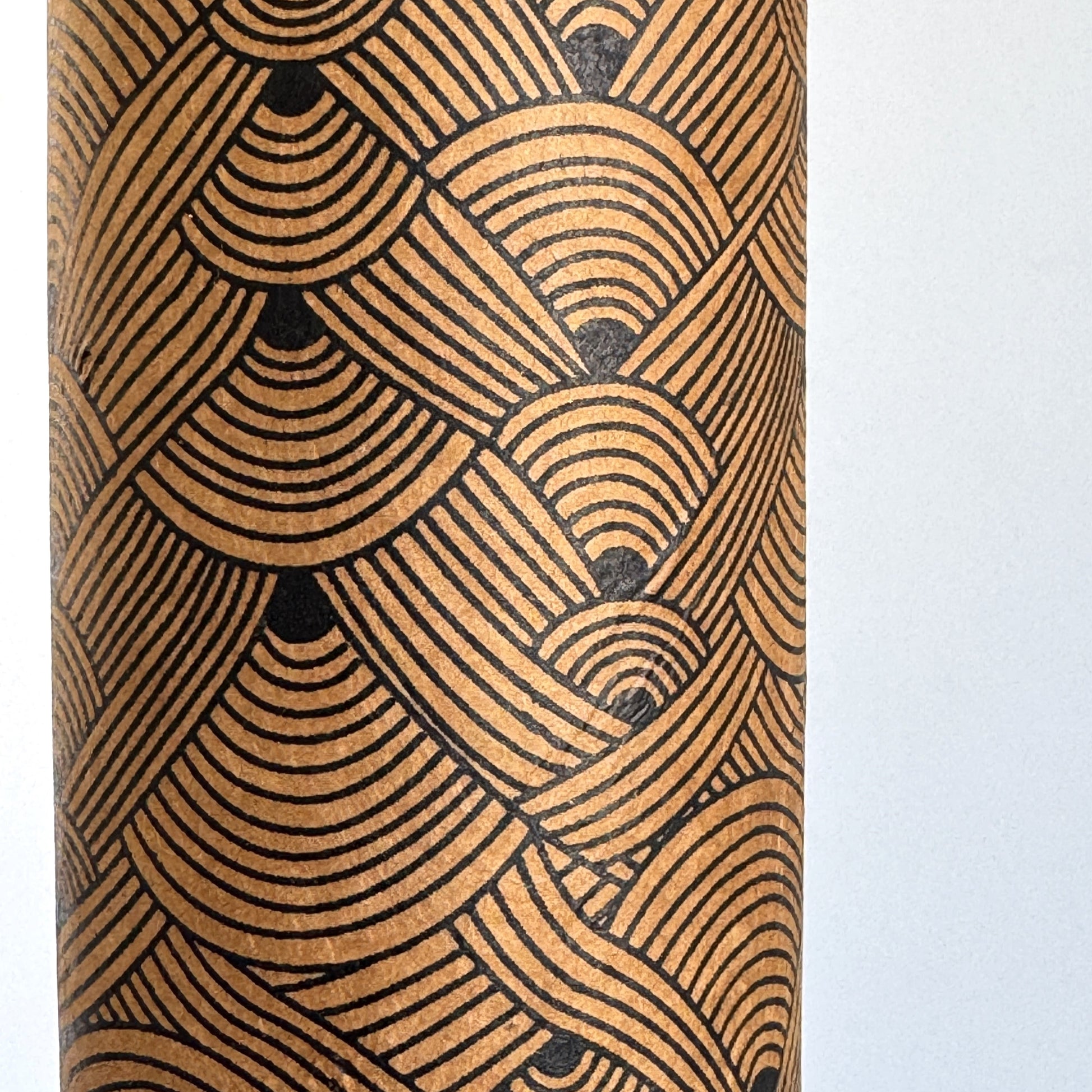 Nepalese handmade decorative lokta paper sheet with a fine lined black knots pattern screen printed on a brown lokta paper. Close up