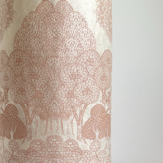 Nepalese handmade decorative lokta paper sheet with a detailed design of trees and flowers in blush pink screen printed on an ivory lokta paper.