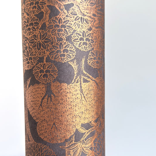 Nepalese handmade decorative lokta paper sheet with a detailed design of trees and flowers in copper screen printed on a dusty violet lokta paper. Close up