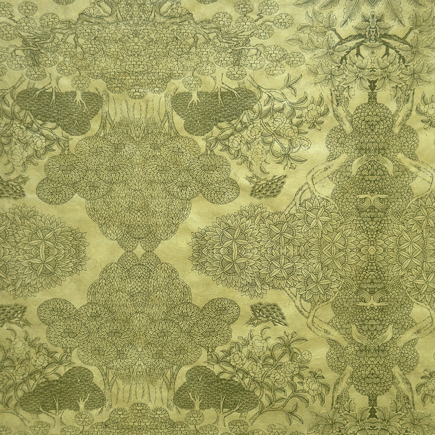 Nepalese handmade decorative lokta paper sheet with a detailed design of trees and flowers in dark green screen printed on a green lokta paper.