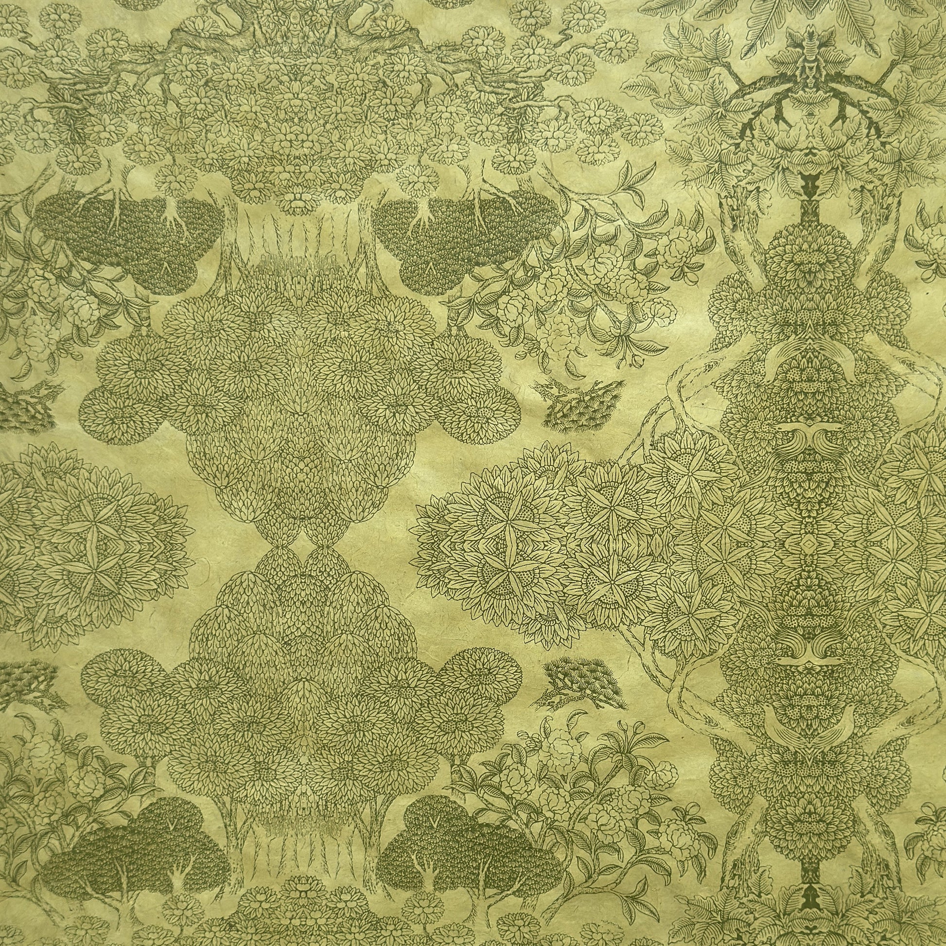 Nepalese handmade decorative lokta paper sheet with a detailed design of trees and flowers in dark green screen printed on a green lokta paper.