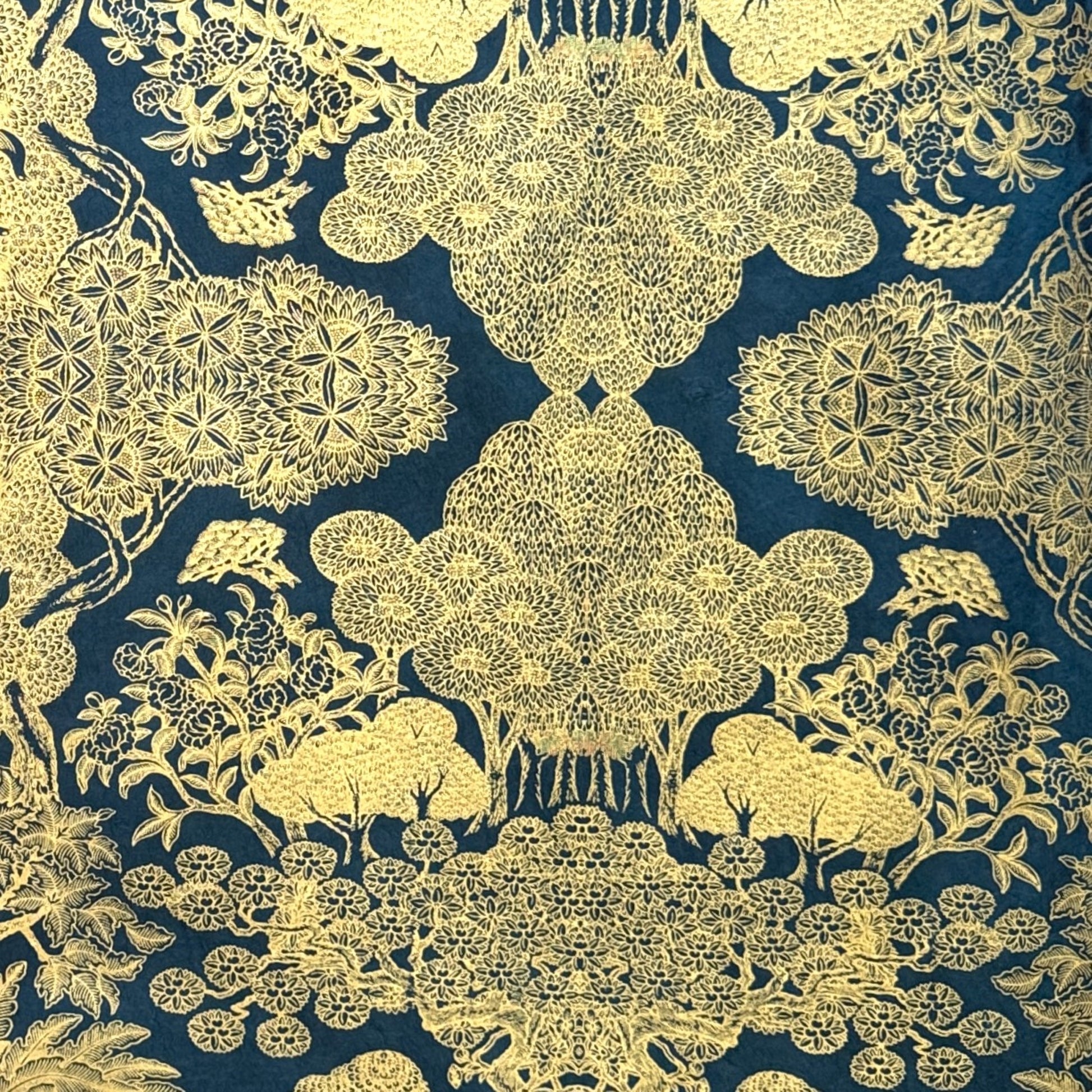 Nepalese handmade decorative lokta paper sheet with a detailed design of trees and flowers in gold metallic screen printed on a midnight blue lokta paper.
