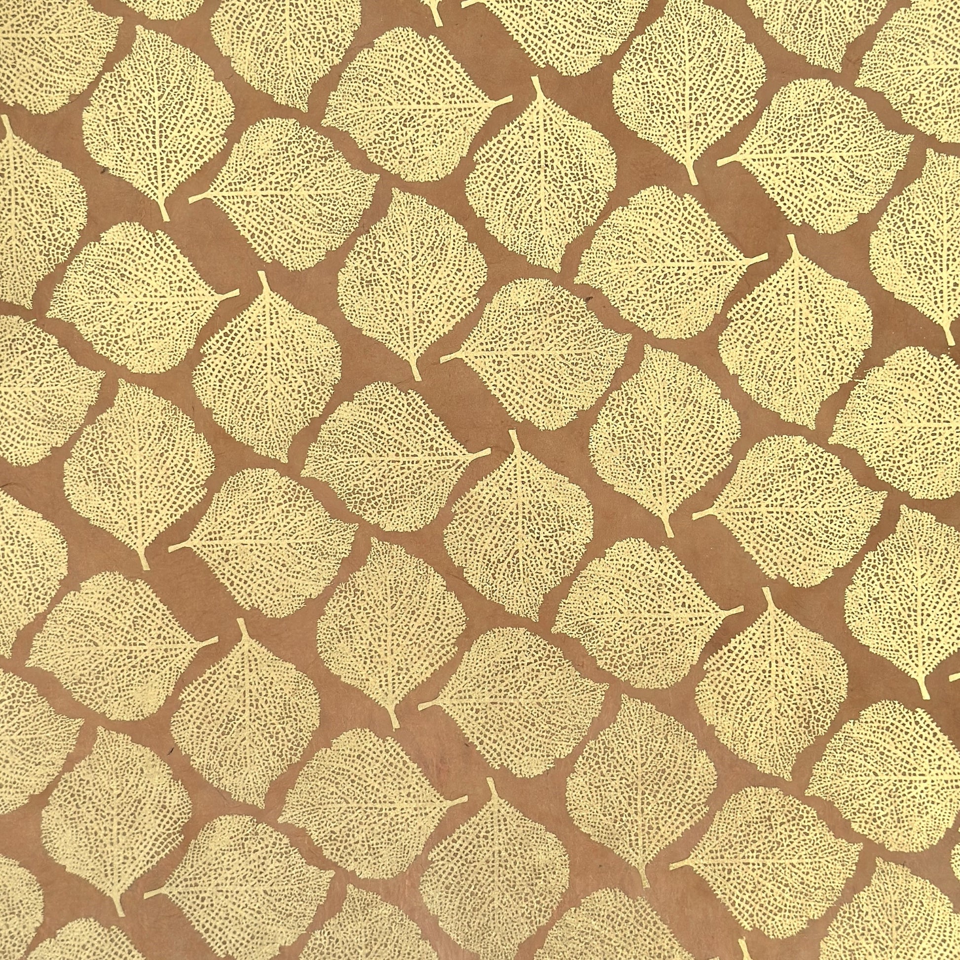Nepalese handmade decorative lokta paper sheet with a gold metallic leaf pattern screen printed on a tan lokta paper.