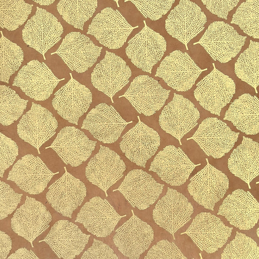 Nepalese handmade decorative lokta paper sheet with a gold metallic leaf pattern screen printed on a tan lokta paper.