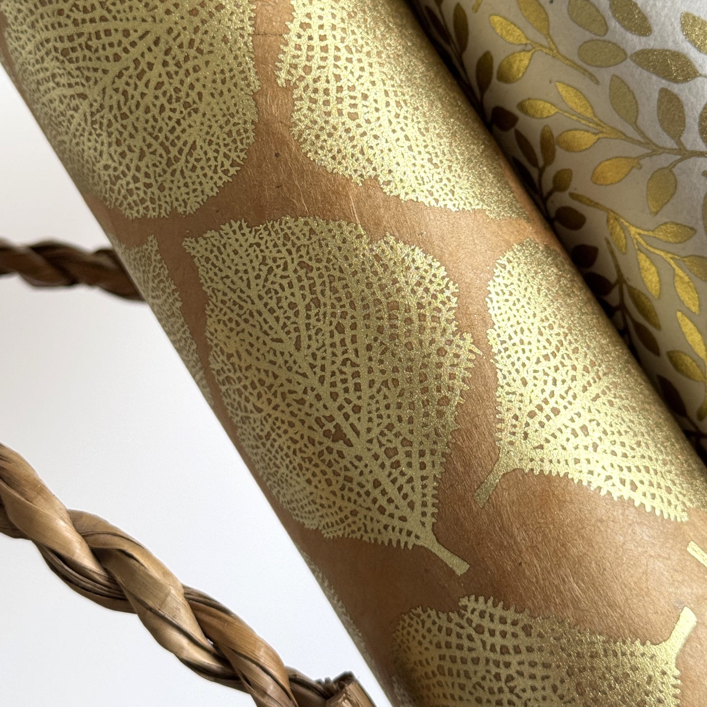 Nepalese handmade decorative lokta paper sheet with a gold metallic leaf pattern screen printed on a tan lokta paper.