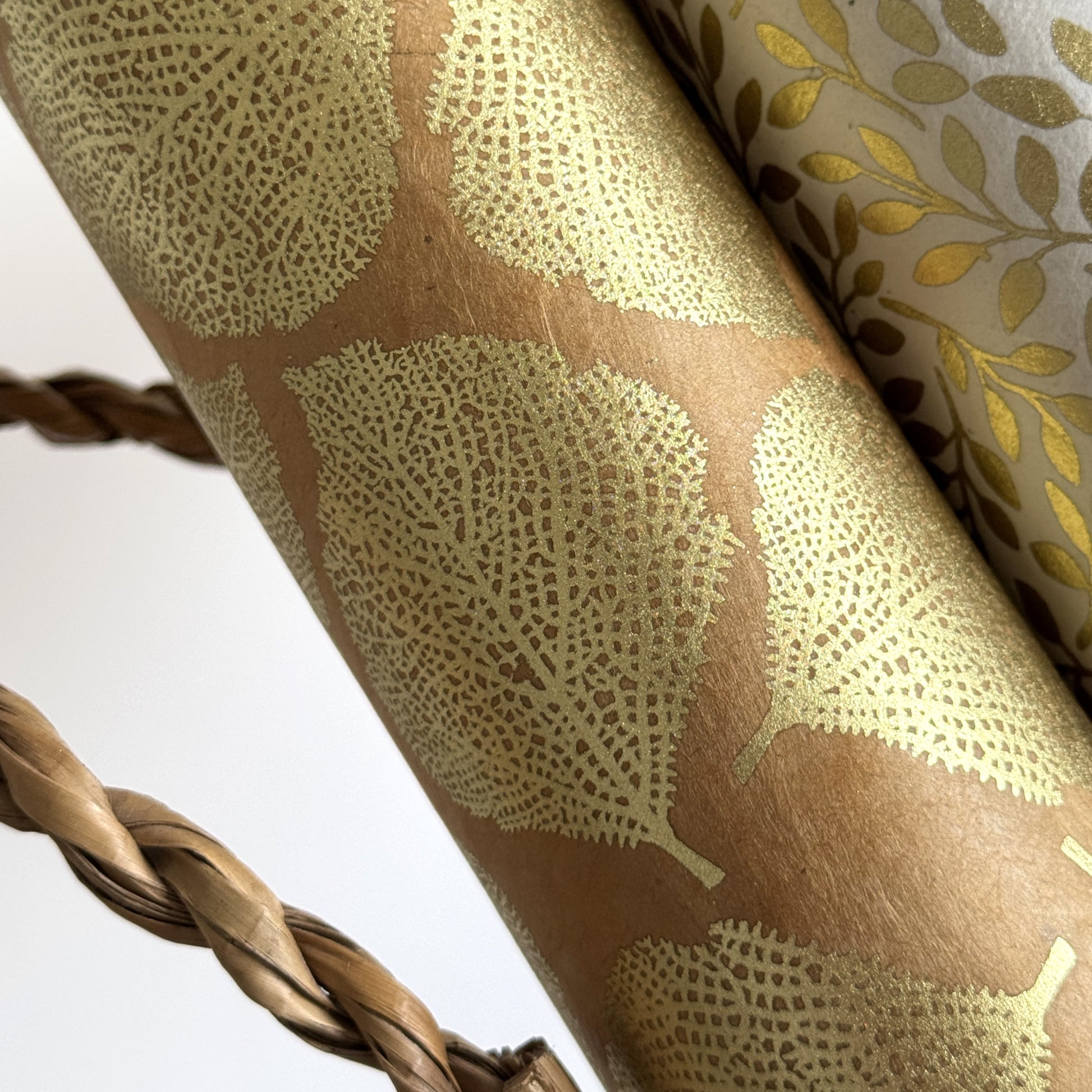 Nepalese handmade decorative lokta paper sheet with a gold metallic leaf pattern screen printed on a tan lokta paper.