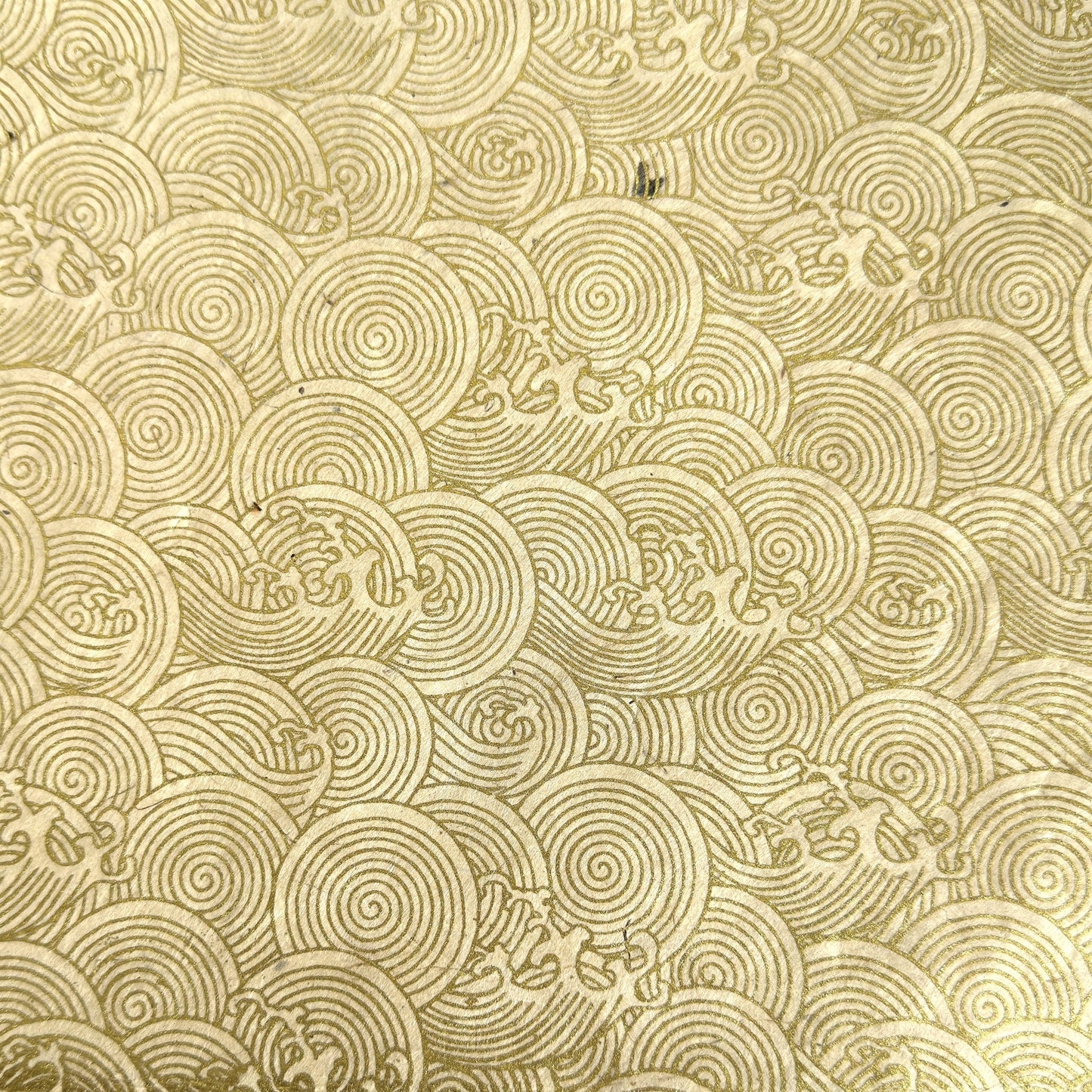 Nepalese handmade decorative lokta paper sheet with a metallic gold wave design screen printed on an ivory lokta paper.