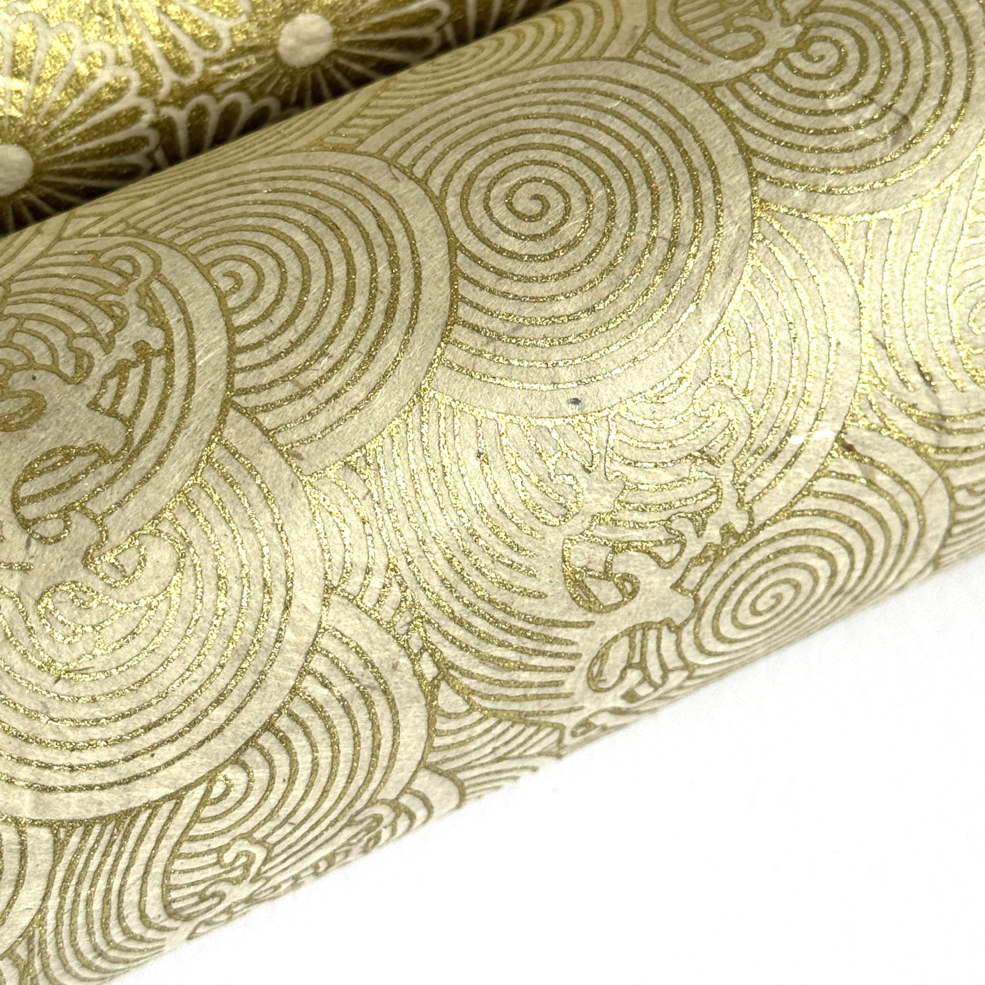 Nepalese handmade decorative lokta paper sheet with a metallic gold wave design screen printed on an ivory lokta paper. close up