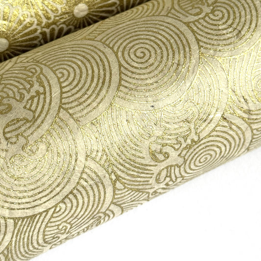 Nepalese handmade decorative lokta paper sheet with a metallic gold wave design screen printed on an ivory lokta paper. close up