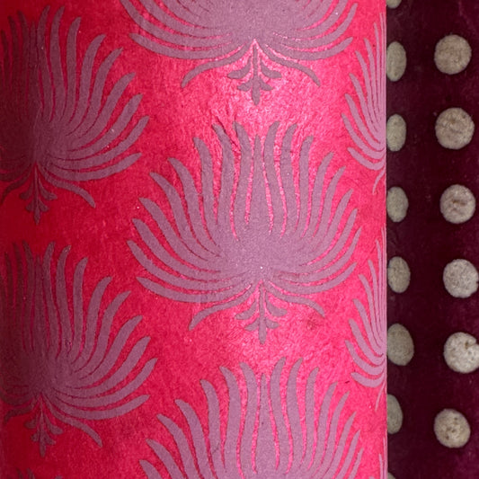 Nepalese handmade decorative lokta paper sheet with a lilac palm leaf design screen printed on a fuchsia pink lokta paper. close up