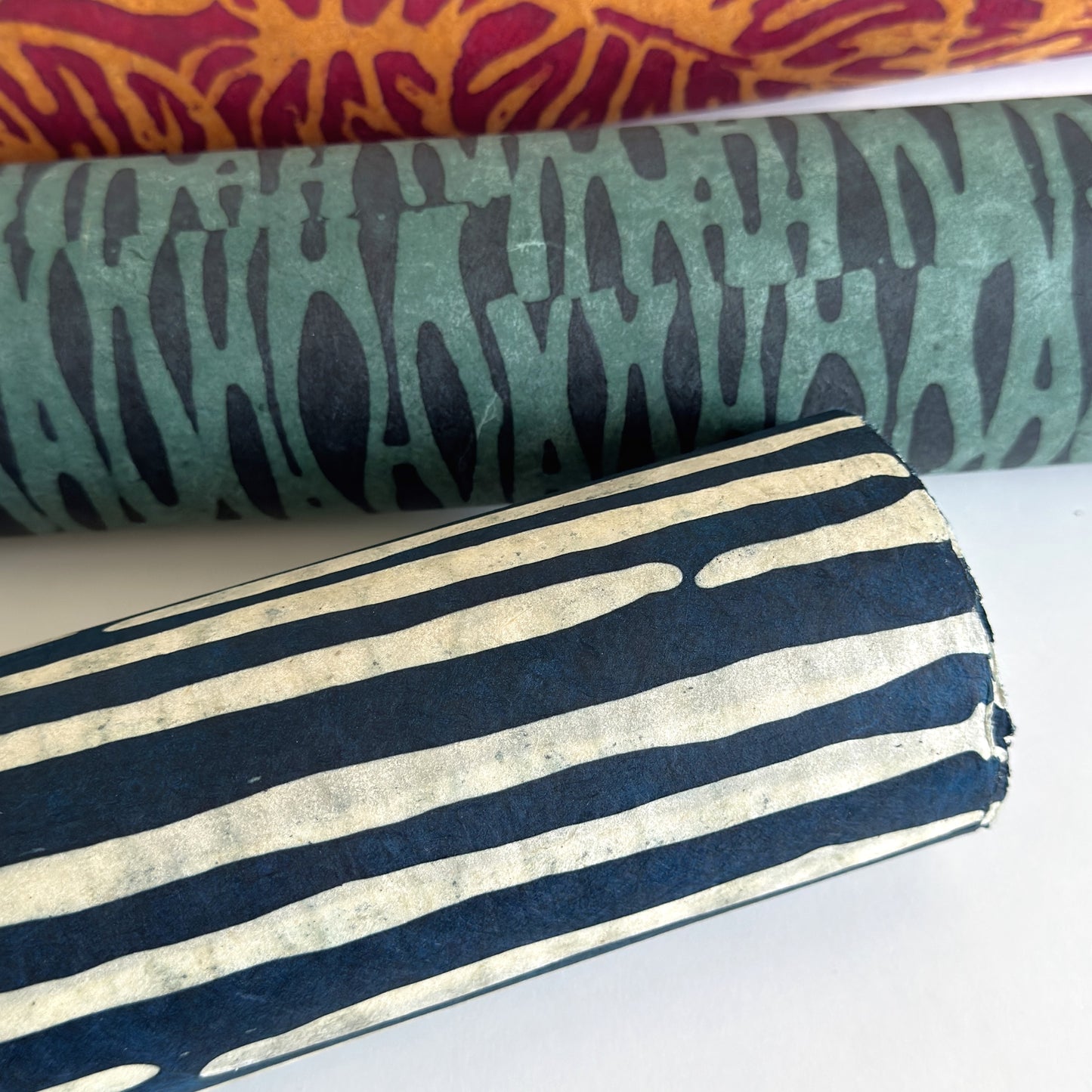 Nepalese handmade decorative lokta paper sheet with a stripe pattern in petrol blue and white.  Batik dyed using carved wooden blocks. Rolled