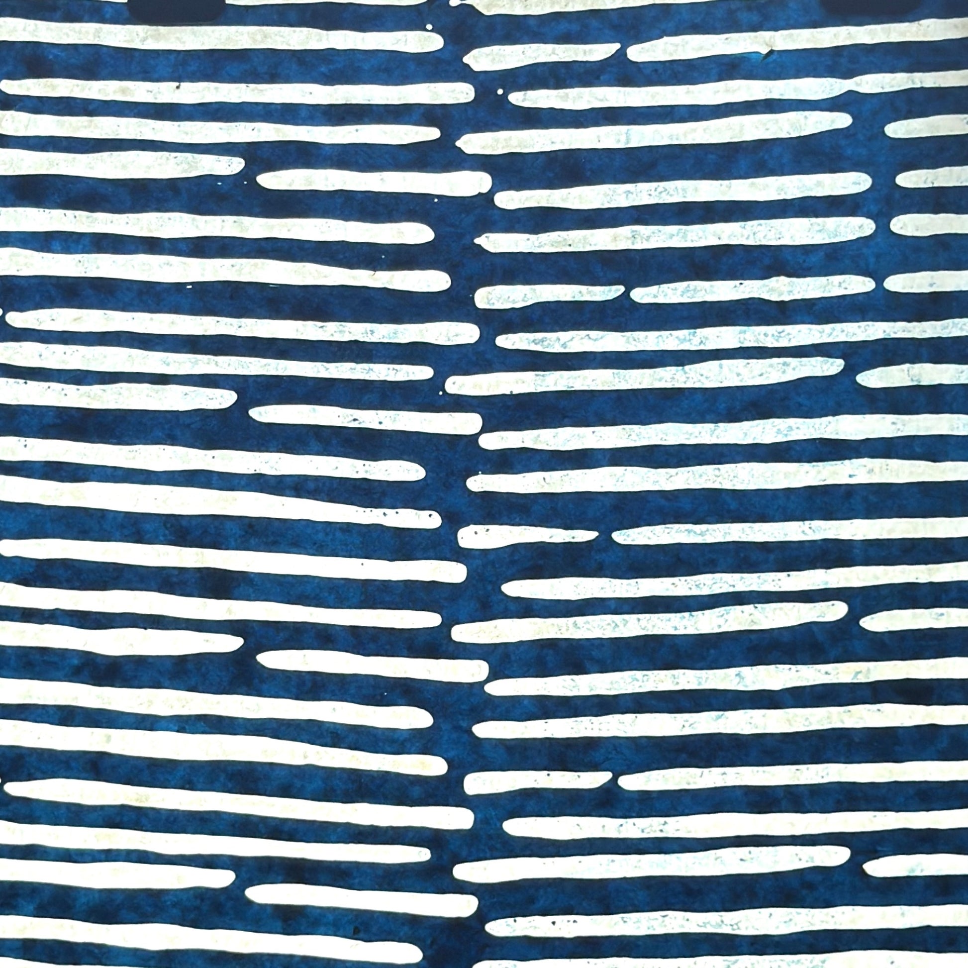 Nepalese handmade decorative lokta paper sheet with a stripe pattern in petrol blue and white.  Batik dyed using carved wooden blocks. Pictured next to light to show the translucent nature