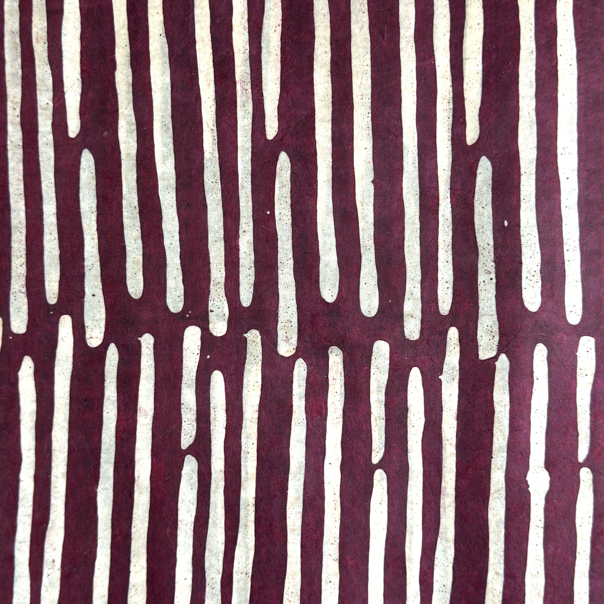 Nepalese handmade decorative lokta paper sheet with a stripe pattern in burgundy and white.  Batik dyed using carved wooden blocks