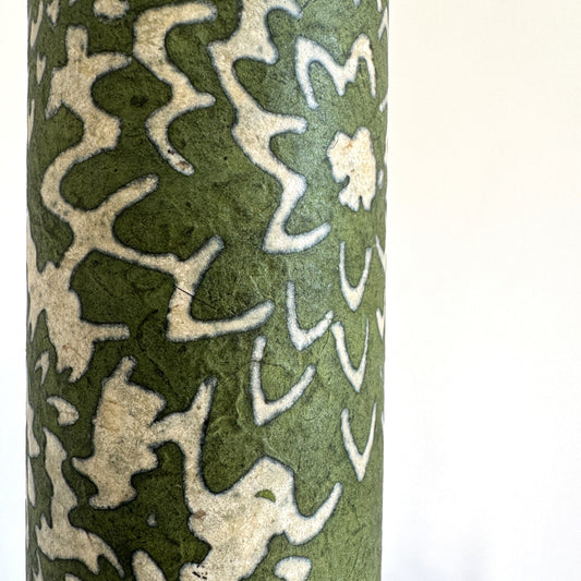 Nepalese handmade decorative lokta paper sheet with a floral pattern in green and cream.  Batik dyed using carved wooden blocks. Close up