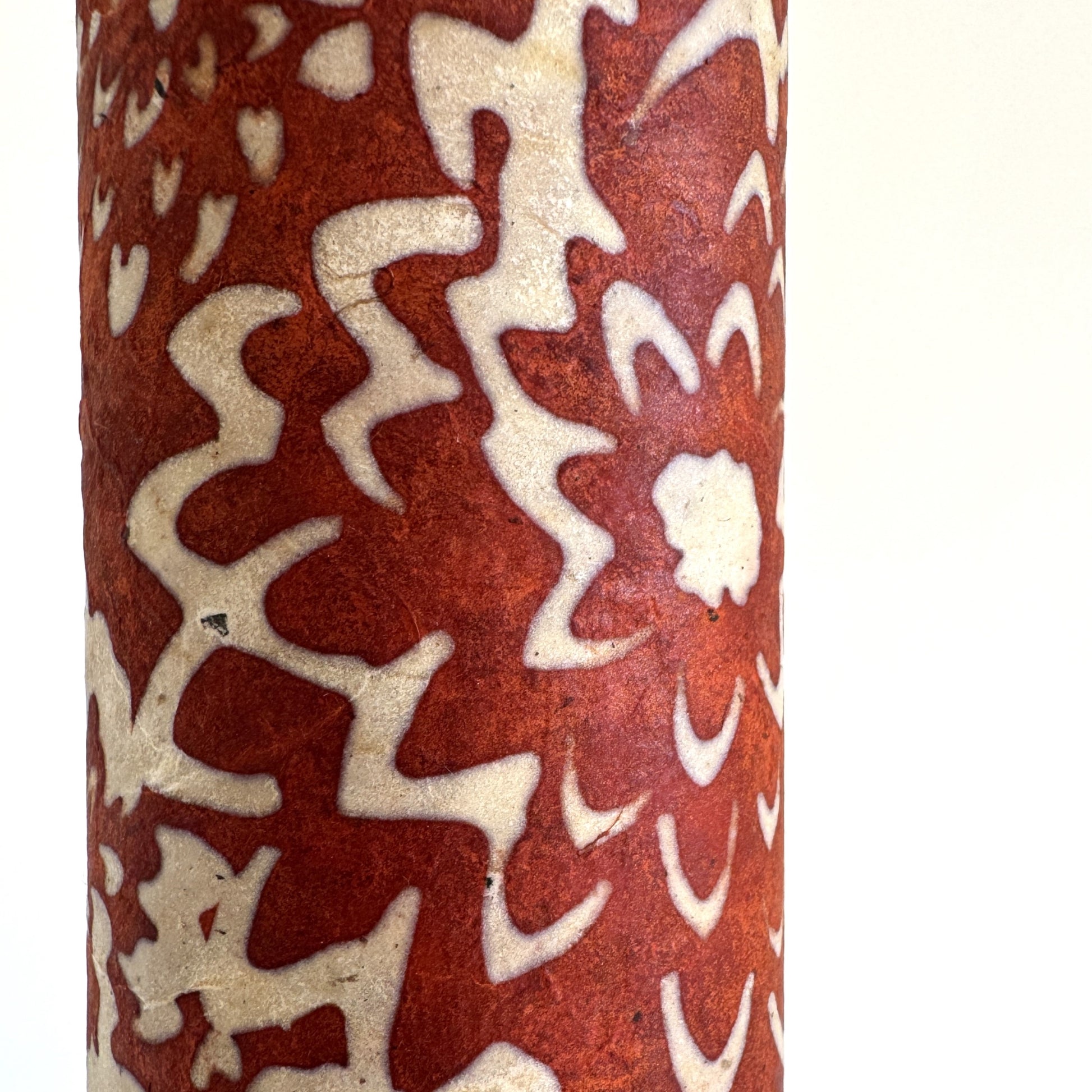 Nepalese handmade decorative lokta paper sheet with a floral pattern in rust and cream.  Batik dyed using carved wooden blocks. Close up