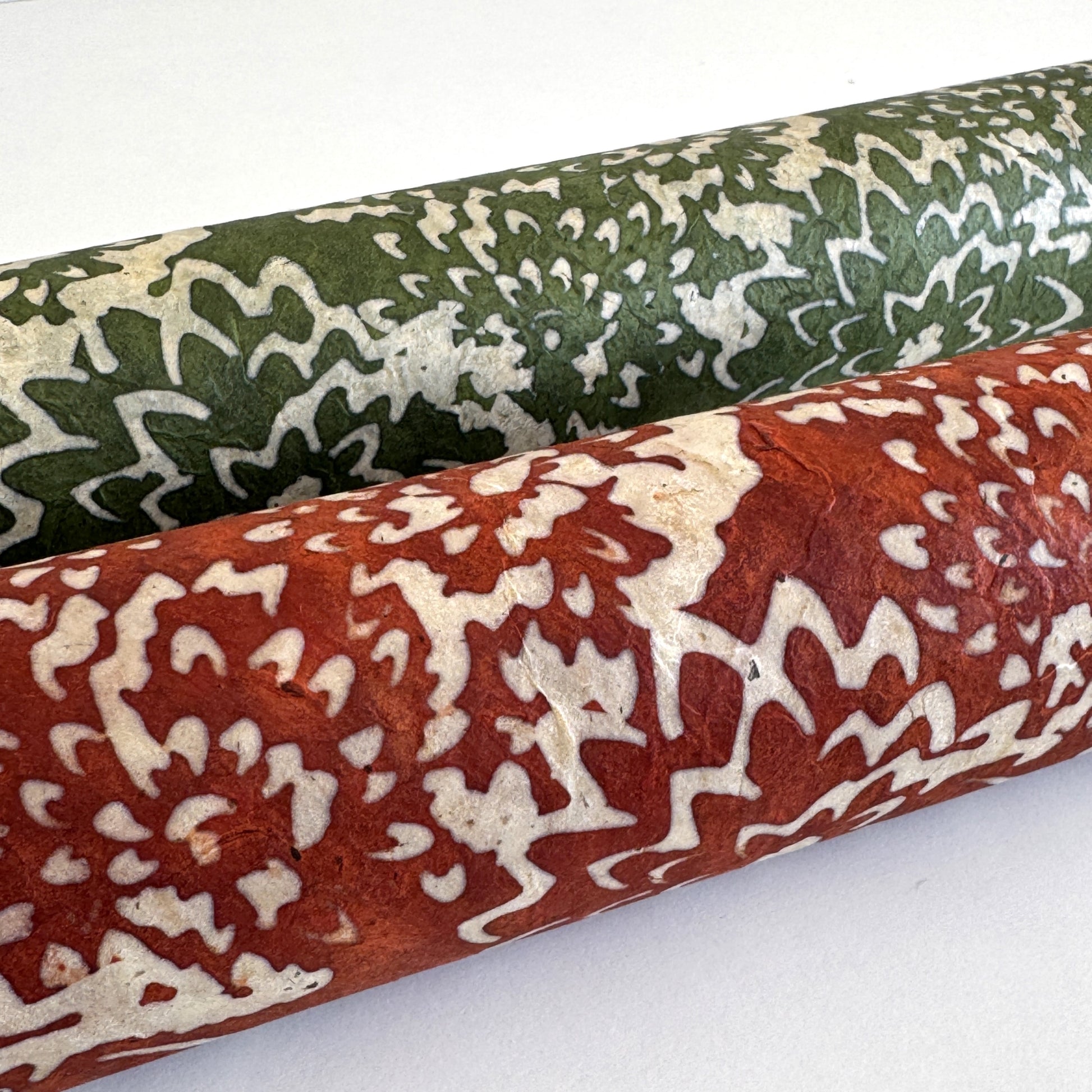 Nepalese handmade decorative lokta paper sheet with a floral pattern in rust and cream.  Batik dyed using carved wooden blocks. Rolled