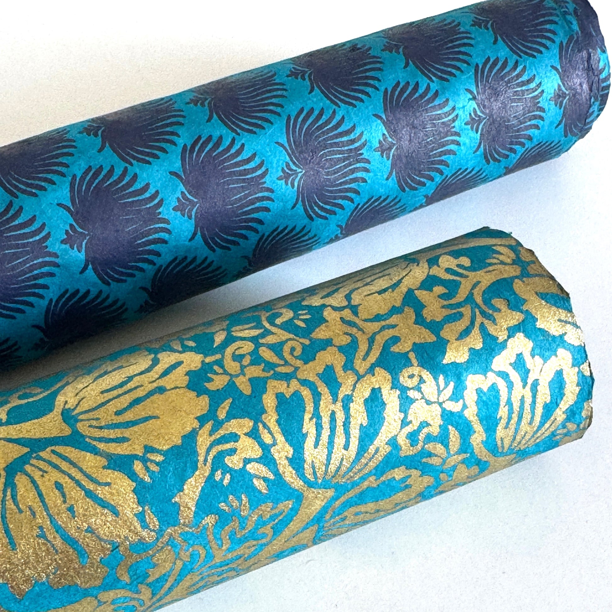 Nepalese handmade decorative lokta paper sheet with a metallic gold tulip design screen printed on a teal lokta paper. Rolled