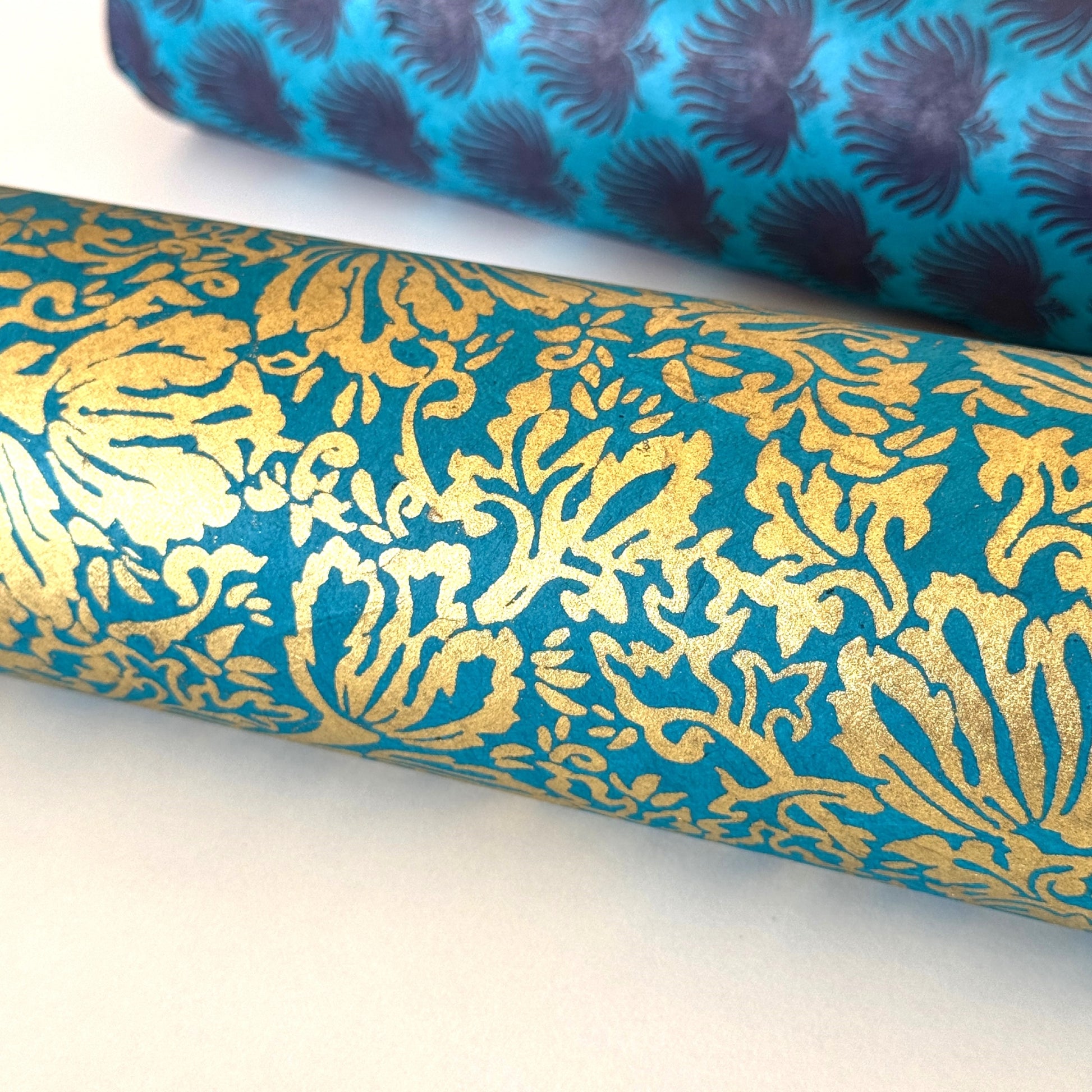 Nepalese handmade decorative lokta paper sheet with a metallic gold tulip design screen printed on a teal lokta paper.
