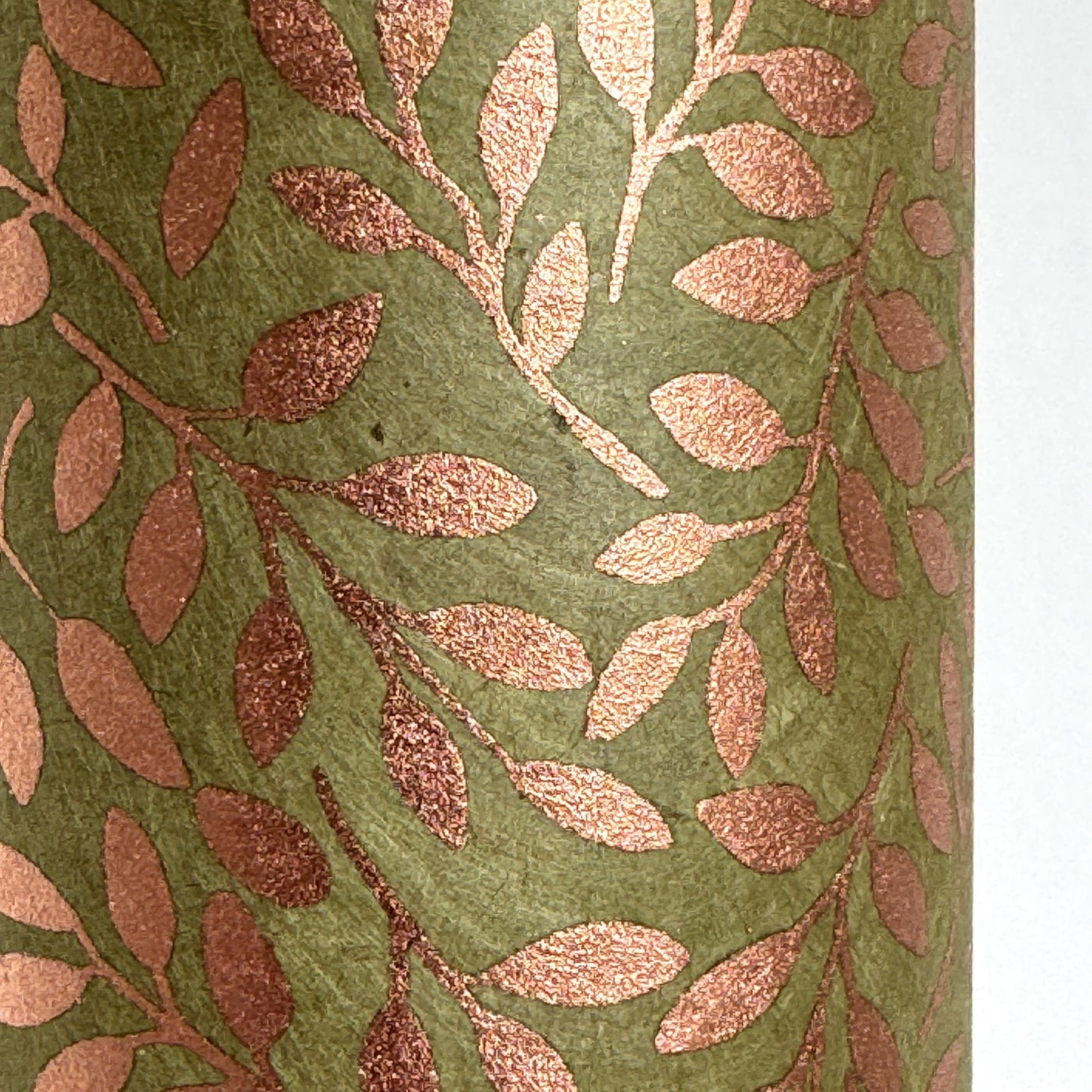 Nepalese handmade decorative lokta paper sheet with a metallic copper willow design screen printed on a dusty moss green lokta paper. Close up