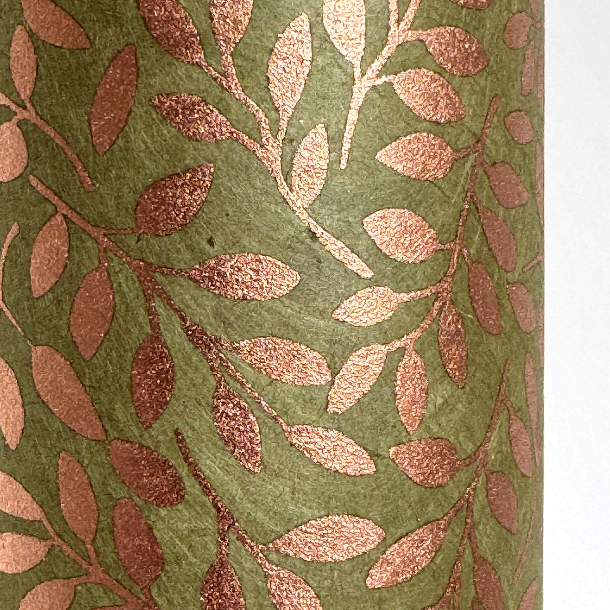 Nepalese handmade decorative lokta paper sheet with a metallic copper willow design screen printed on a dusty moss green lokta paper. Close up