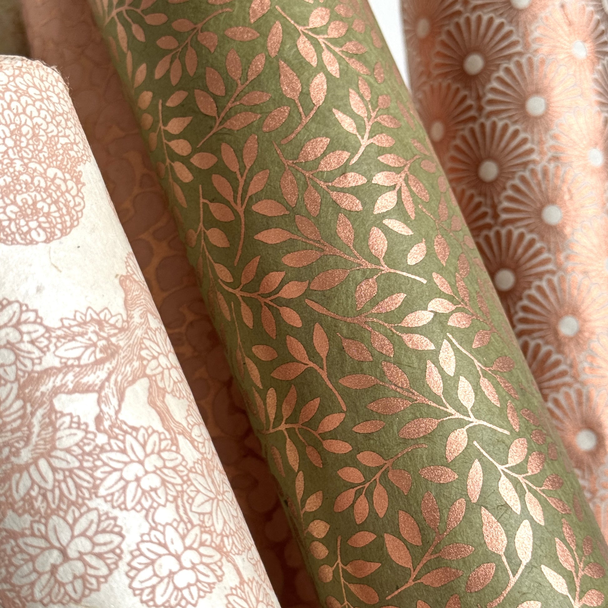 Nepalese handmade decorative lokta paper sheet with a metallic copper willow design screen printed on a dusty moss green lokta paper. Rolled