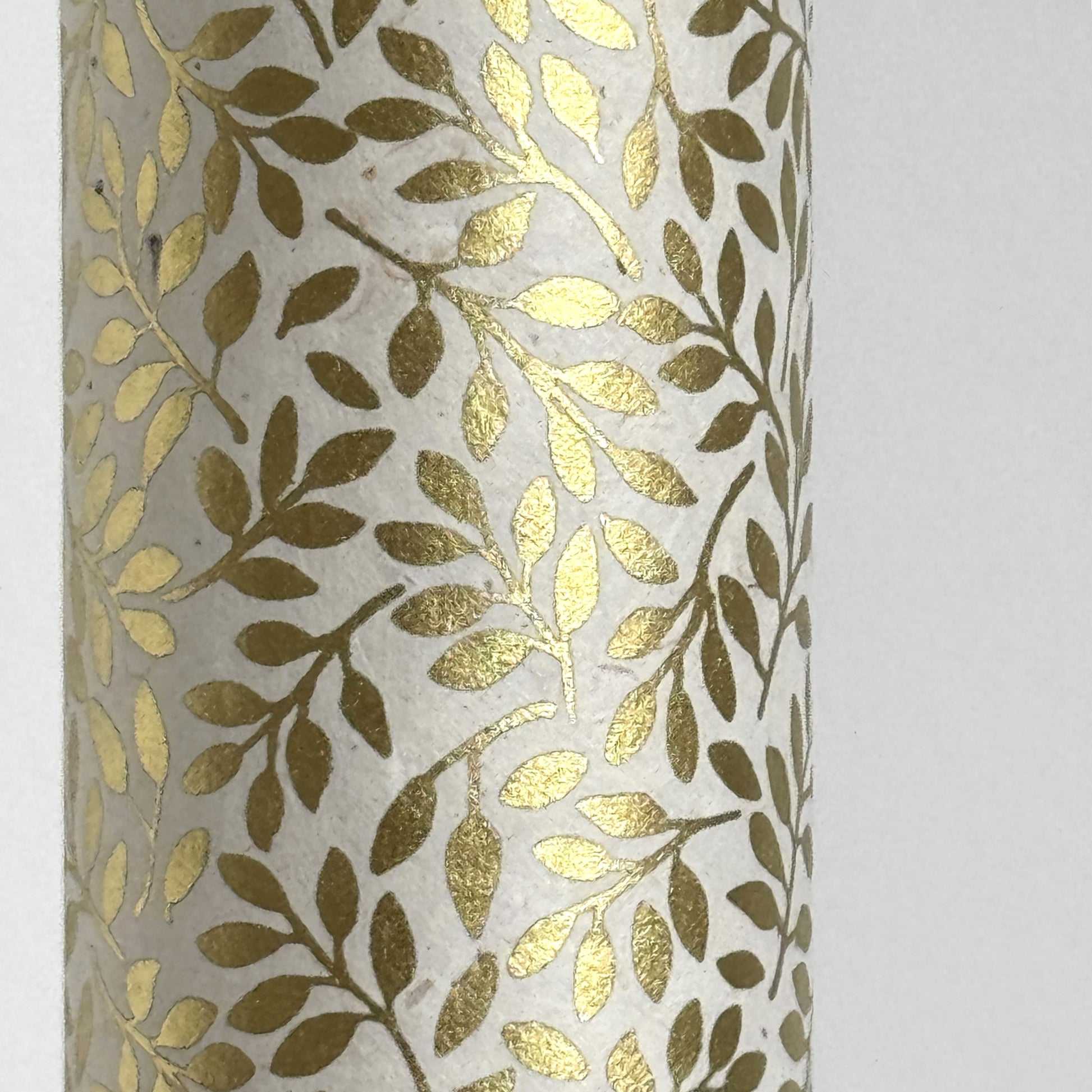 Nepalese handmade decorative lokta paper sheet with a metallic gold willow design screen printed on an ivory lokta paper. Close up