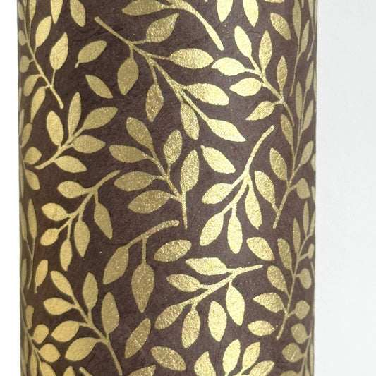 Nepalese handmade decorative lokta paper sheet with a metallic gold willow design screen printed on a dusty grape lokta paper. Close up