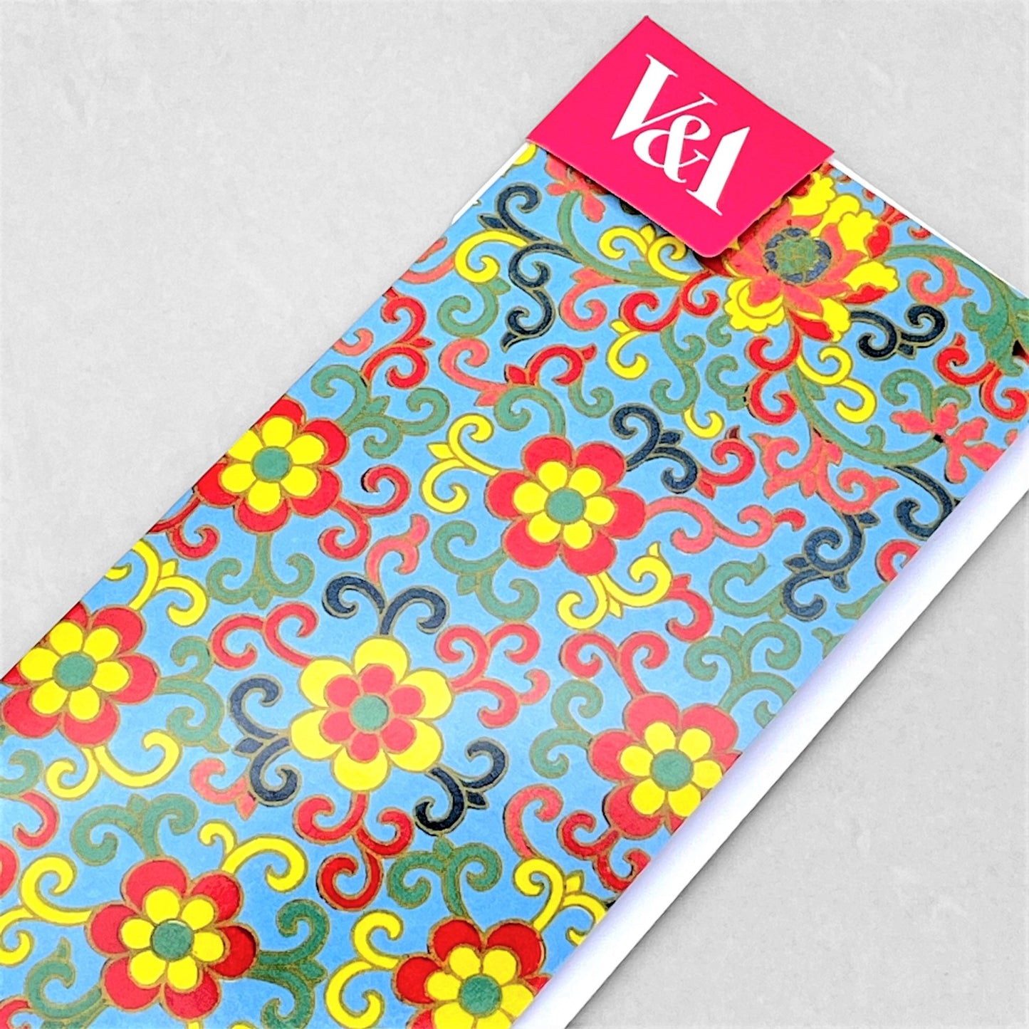 greetings card showing a floral repeat pattern in yellow and red on an aqua backdrop
