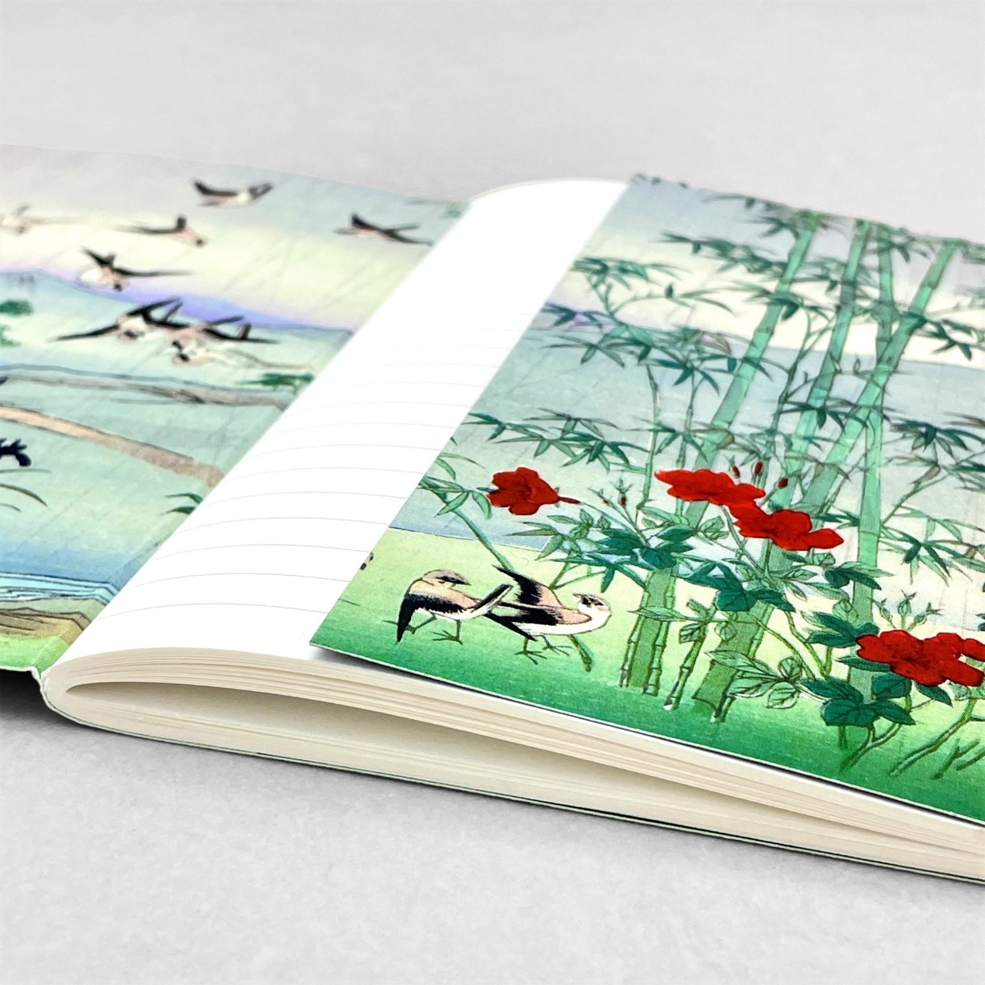 Small stitched notebook with a japanese design showing sparrows and bamboo in the rain