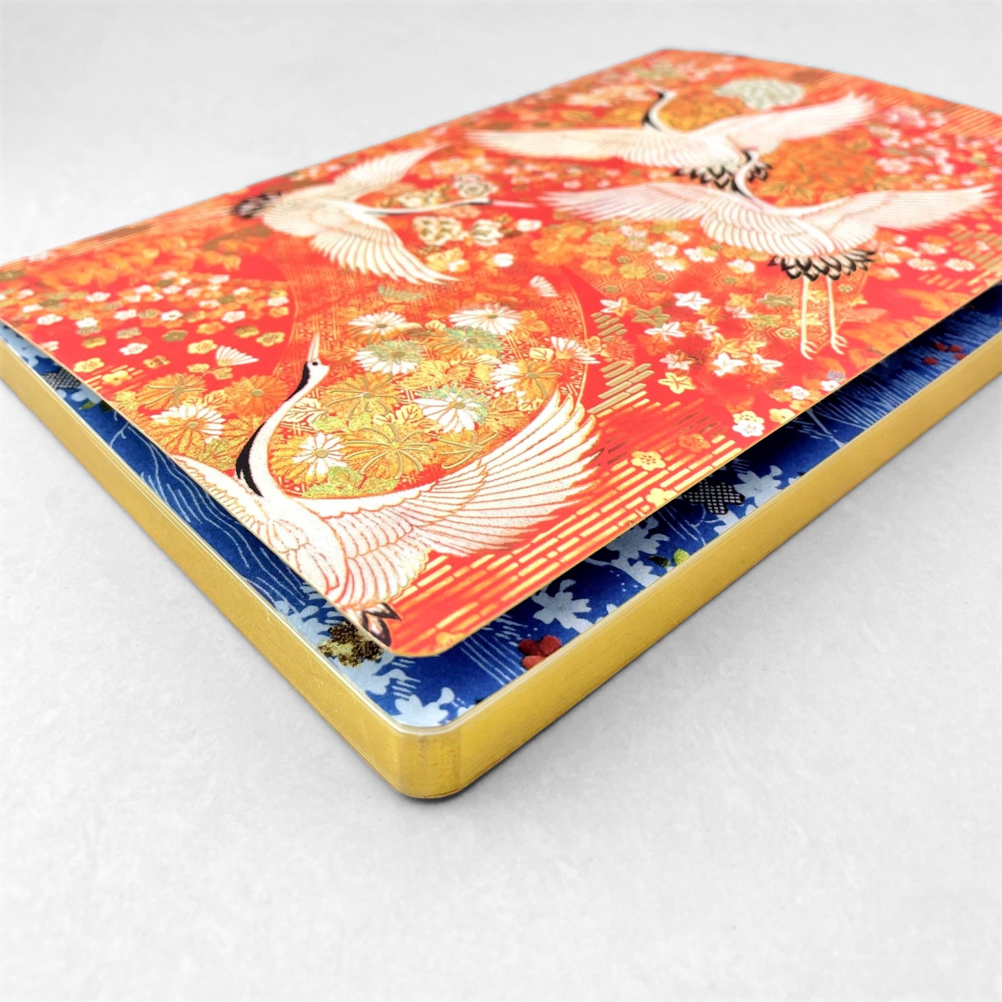 A5 lined notebook with a japanese cover design with white swans on an orange background