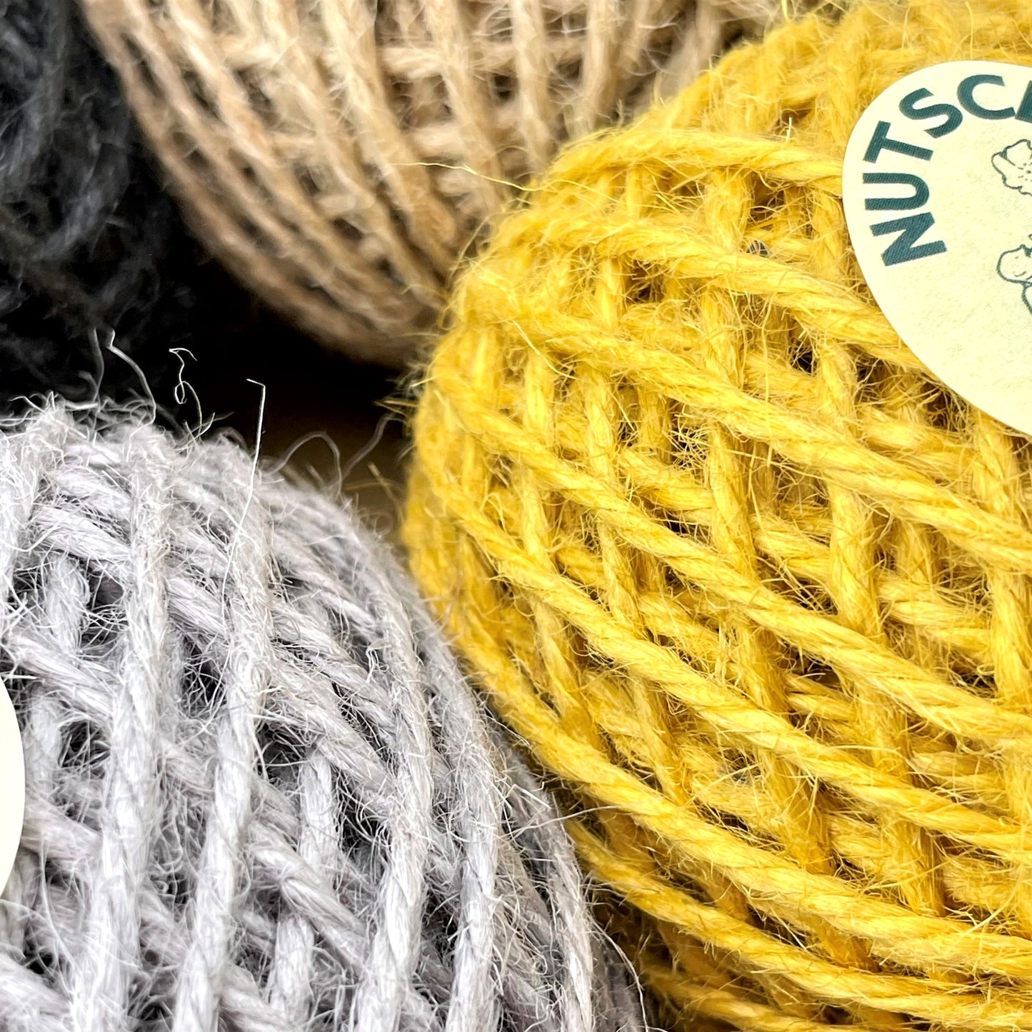Gift box of 6 coloured jute twine balls by Nutscene. Close up of the balls of twine showing the mustard yellow and grey.