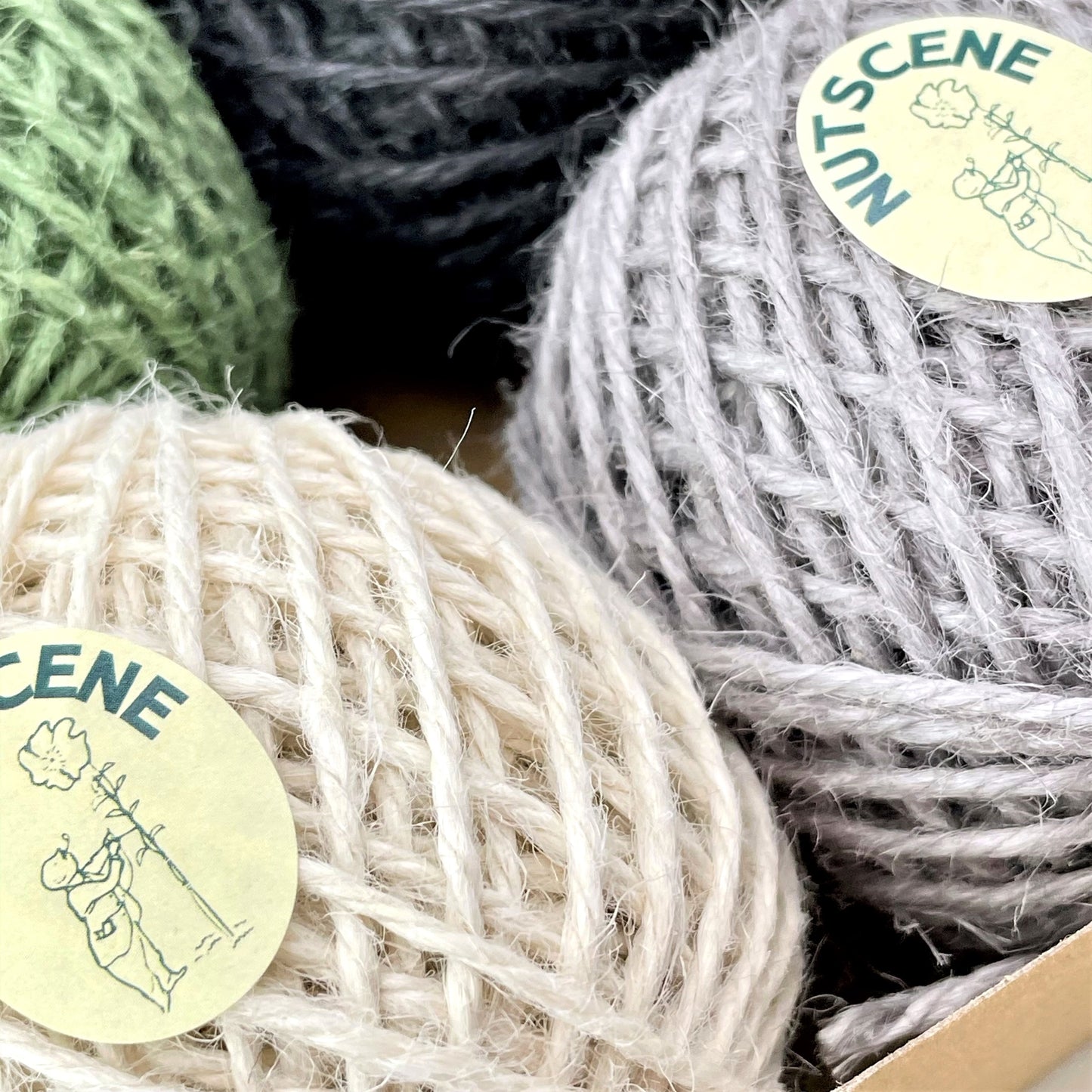 Gift box of 6 coloured jute twine balls by Nutscene. Close up of the balls of twine showing the white and grey.