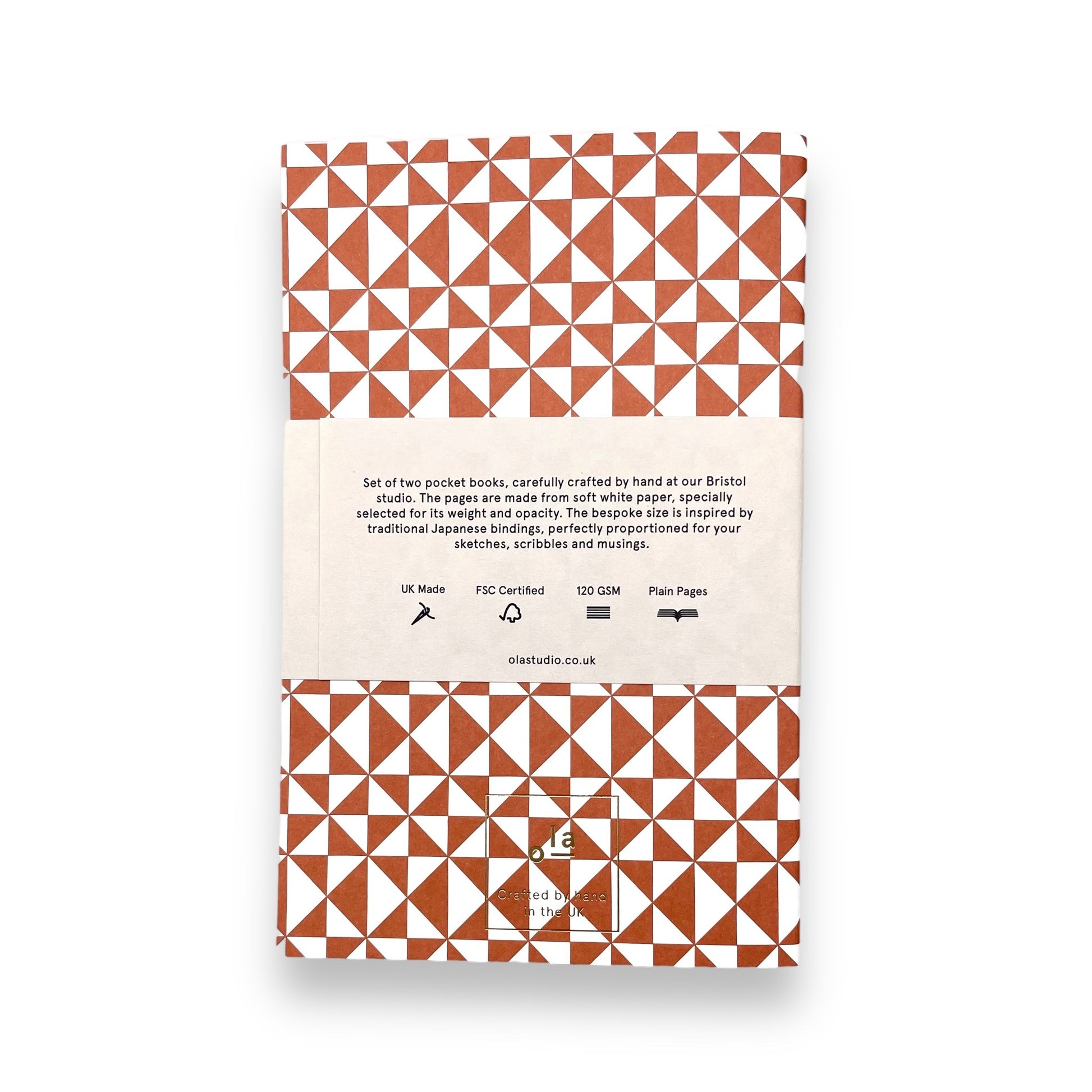 A set of two softcover pocket notebooks by Ola Studio. Two different cover design, one is a circle geometric in pick and orange, the other a triangular geometry in brick red. reverse of packaging pictured