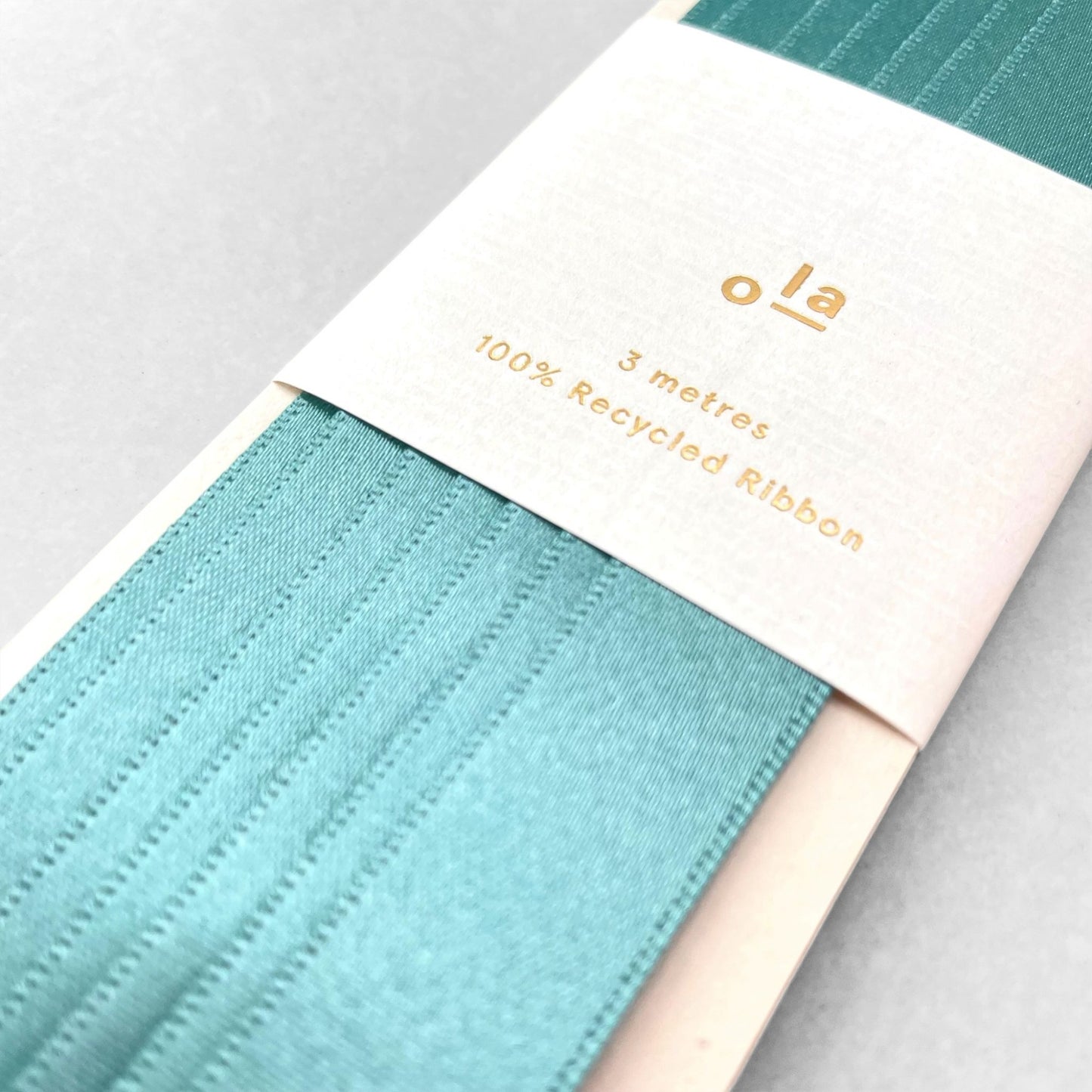 Luxury calamine blue satin ribbon on a rectangular board by Ola Studio