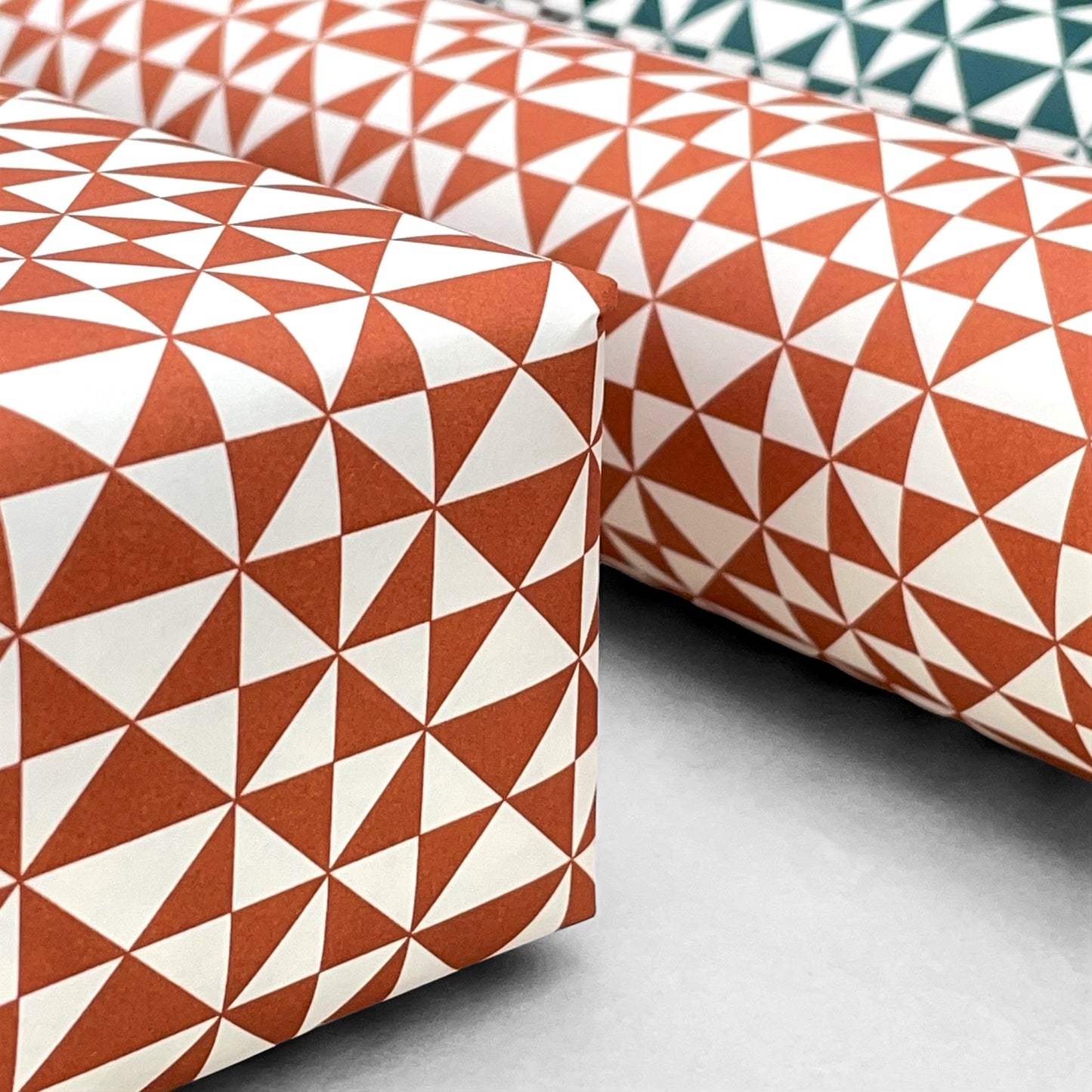 wrapping paper with an abstract triangle pattern in brick red and white by Ola Studio