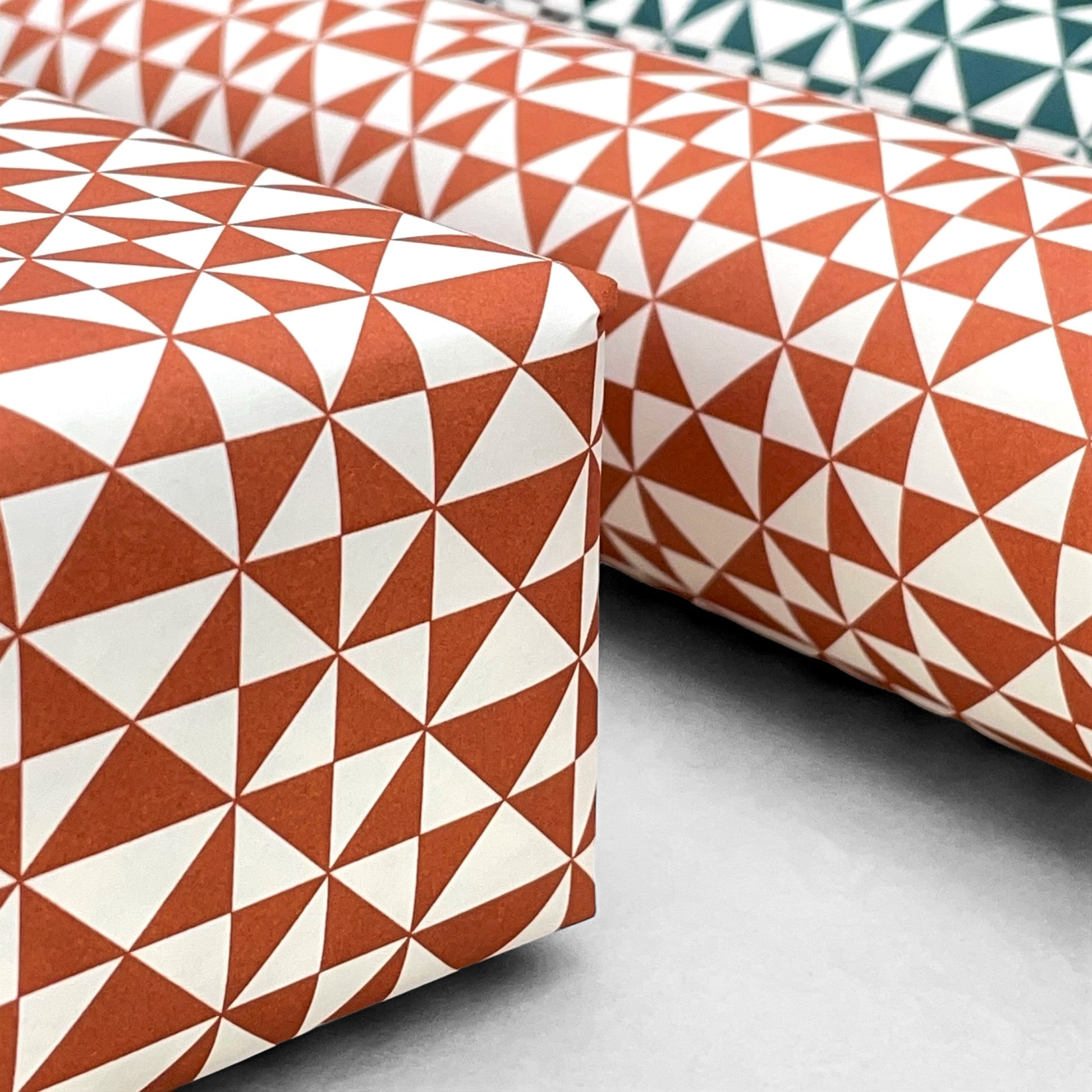 wrapping paper with an abstract triangle pattern in brick red and white by Ola Studio